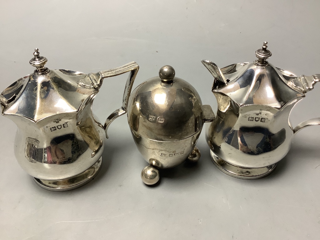 A pair of octagonal silver mustard pots and spoons, an egg-shaped salt, a baluster pepper, a small toast rack and four silver wine labels, approximately 13.5oz